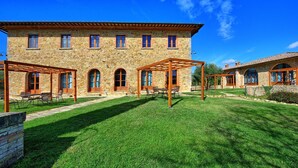A stone building with a covered patio area, multiple windows, and a well-maintained lawn. - Lovely apartment for 3 guests with WIFI, pool, TV and pets allowed (Molino D'elsa)