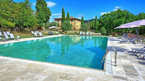 A clear blue pool with lounge chairs and umbrellas, surrounded by trees and a stone building. - Lovely apartment for 3 guests with WIFI, pool, TV and pets allowed (Molino D'elsa)