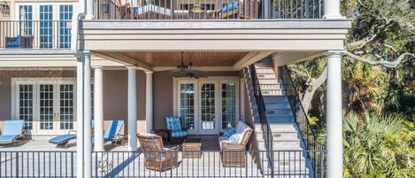 A two-story balcony with wicker furniture and a covered seating area.