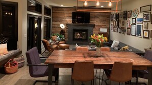 A modern dining room with a large wooden table, leather chairs, and a fireplace. - Beautiful and Spacious home only 5 minute drive to Canyons Resort---Sleeps 10 (Park City)