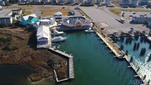 An aerial view of a waterfront property with a dock, boats, and a marina.