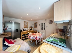 A compact kitchen with a dining table, a refrigerator, and a microwave. - Homerez - Apartment Gérardmer (Gérardmer)
