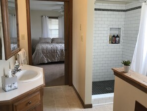 Een aparte badkuip en douche, een haardroger, handdoeken, zeep