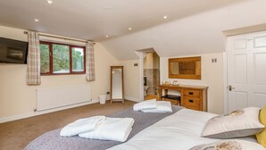 Un dormitorio con cama, cómoda, espejo, ventana con cortinas y televisor en la pared.