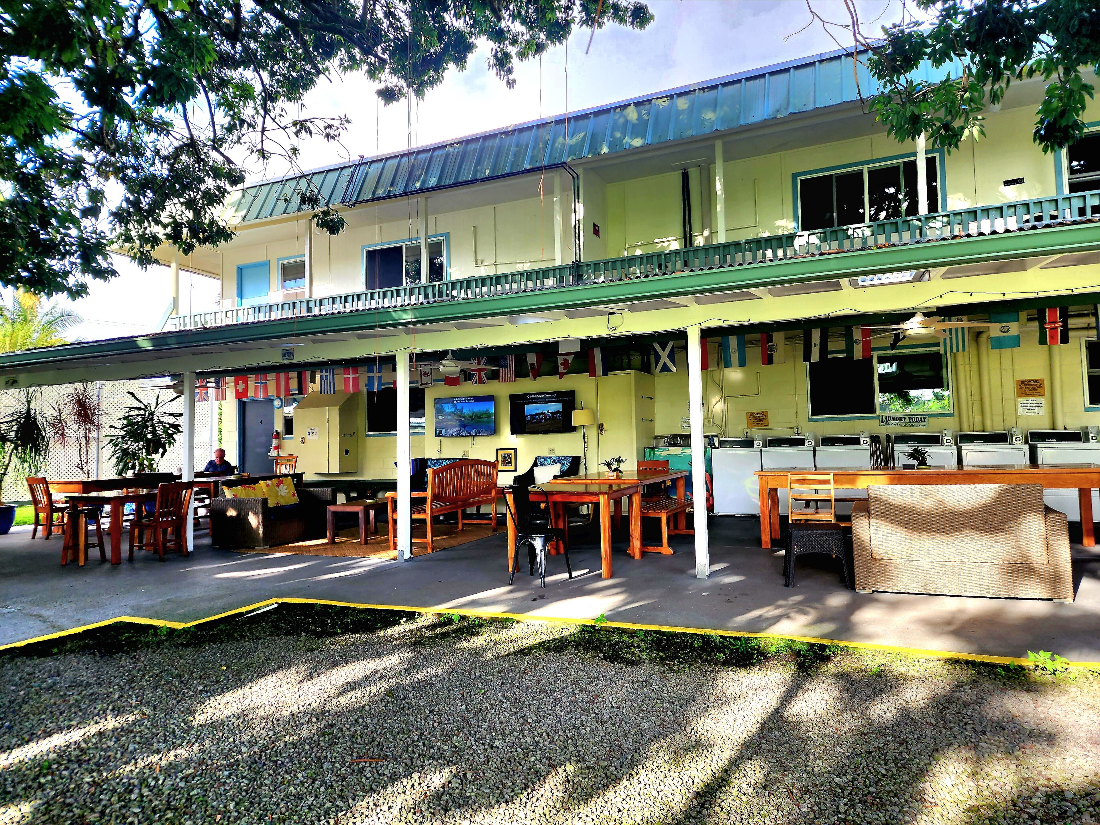 A building with a covered outdoor seating area, a laundry facility, and a sign indicating laundry services.