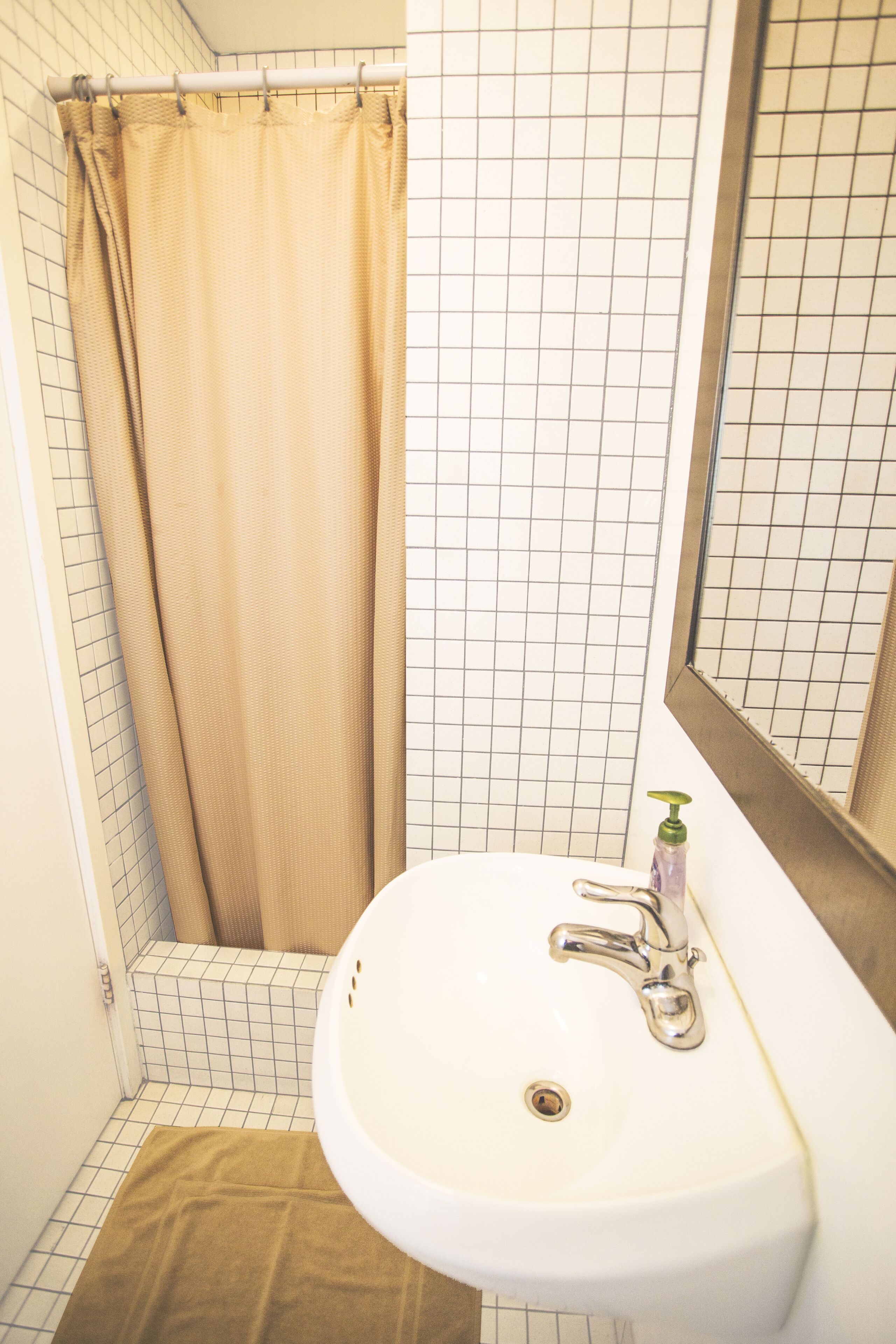 A bathroom with a white sink, a mirror, and a shower curtain.