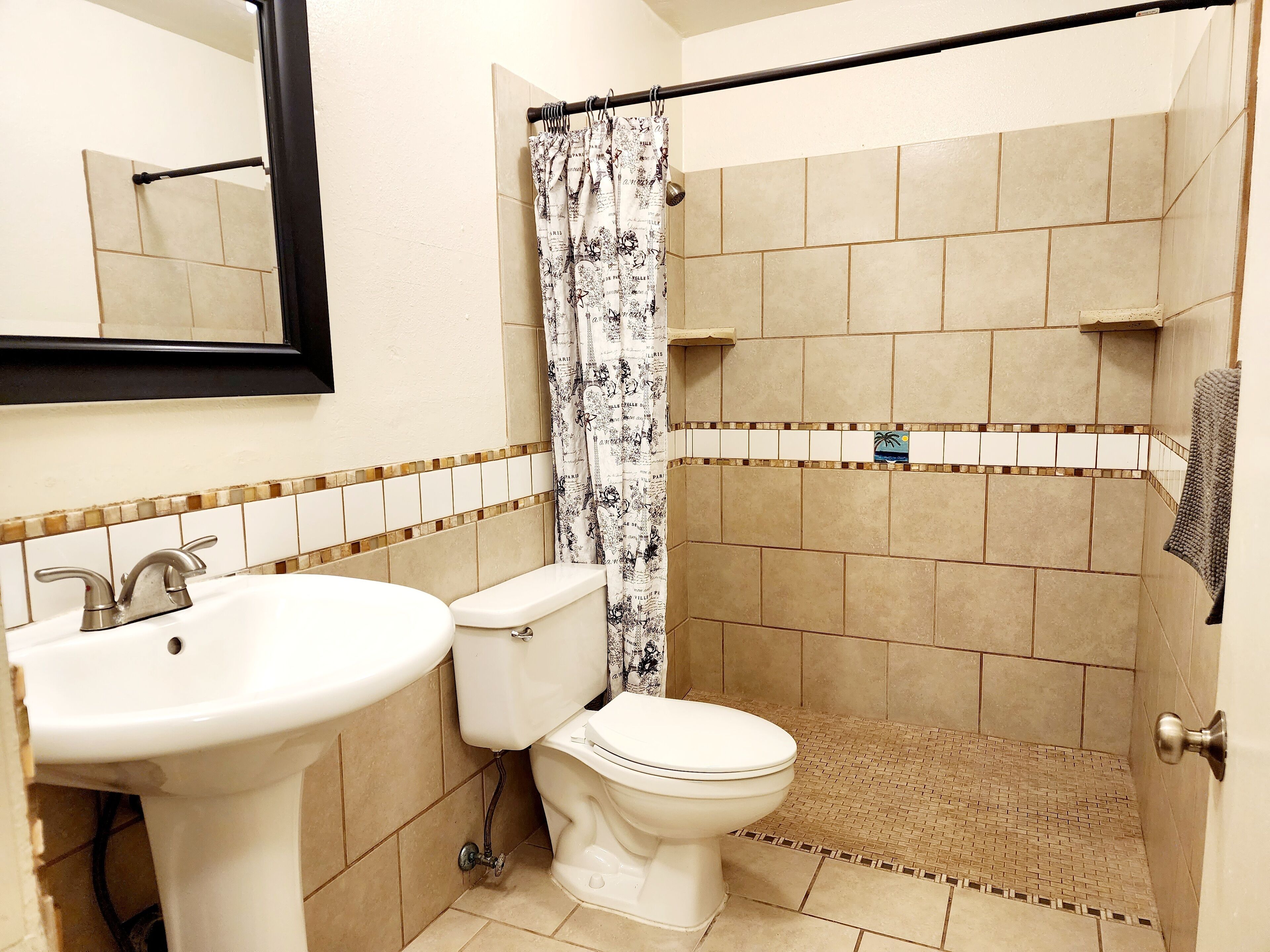 Een badkamer met toilet, wastafel en douche.
