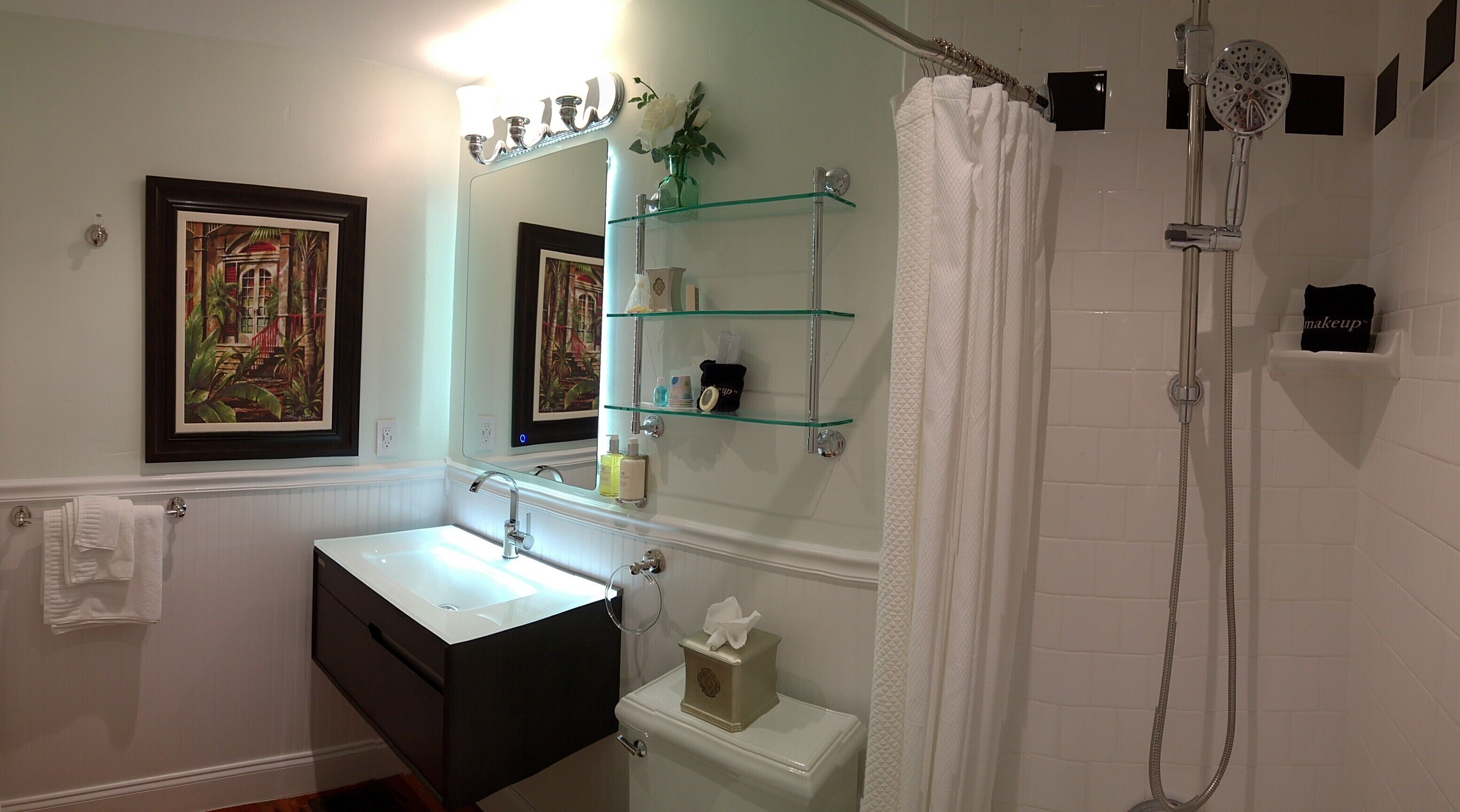 A bathroom with a sink, mirror, shelves, and a shower.