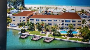 Ein Hotel mit Pool, anglegerten Booten und Blick auf den Strand.