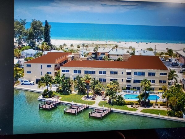 Un hotel con piscina, barcos amarrados y vista a la playa.