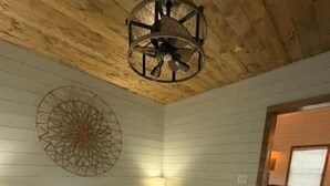 A bedroom with a large bed, a wall clock, and a ceiling fan. - Black Hills Farmhouse, Guest House #1 (Custer)