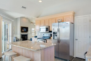 A modern kitchen with granite countertops, stainless steel appliances, and wooden cabinetry.