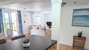 A modern kitchen with granite countertops, wooden cabinets, and a central island with a potted plant.