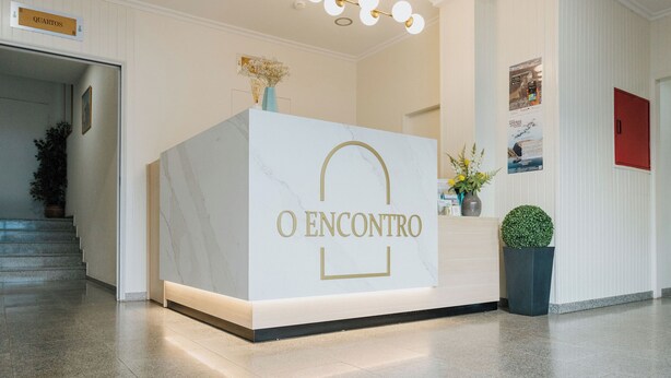 A reception desk with a marble top and a sign reading "O ENCONTRO". - Hotel O Encontro (Miranda do Douro)