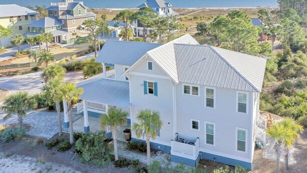 A coastal residential area with multiple houses, including a prominent white house with a gabled roof and a balcony. - So close to the pool! Beach Views, Multiple Decks, Gated Community. ~Brise Del M (Cape San Blas)