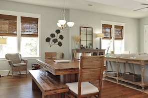 A dining area with a wooden table, chairs, and a chandelier. - So close to the pool! Beach Views, Multiple Decks, Gated Community. ~Brise Del M (Cape San Blas)