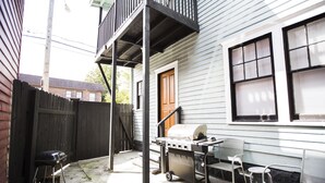 A backyard with a grill, chairs, and a wooden fence. - Your own historic estate in the heart of Old Louisville! NEAR IT All!! (Louisville)