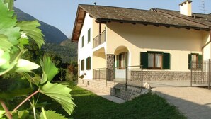 A two-story house with a stone facade, green shutters, and a balcony. - B&B Carunei (Poggiridenti)