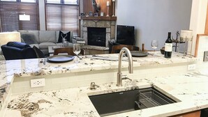 A kitchen with a sink, countertop, and a fireplace with a deer head decoration. - TRUE Ski-In Ski-Out Luxury 2 bd. 2 bth -Riverbend Lodge -Perfect location! (Breckenridge)