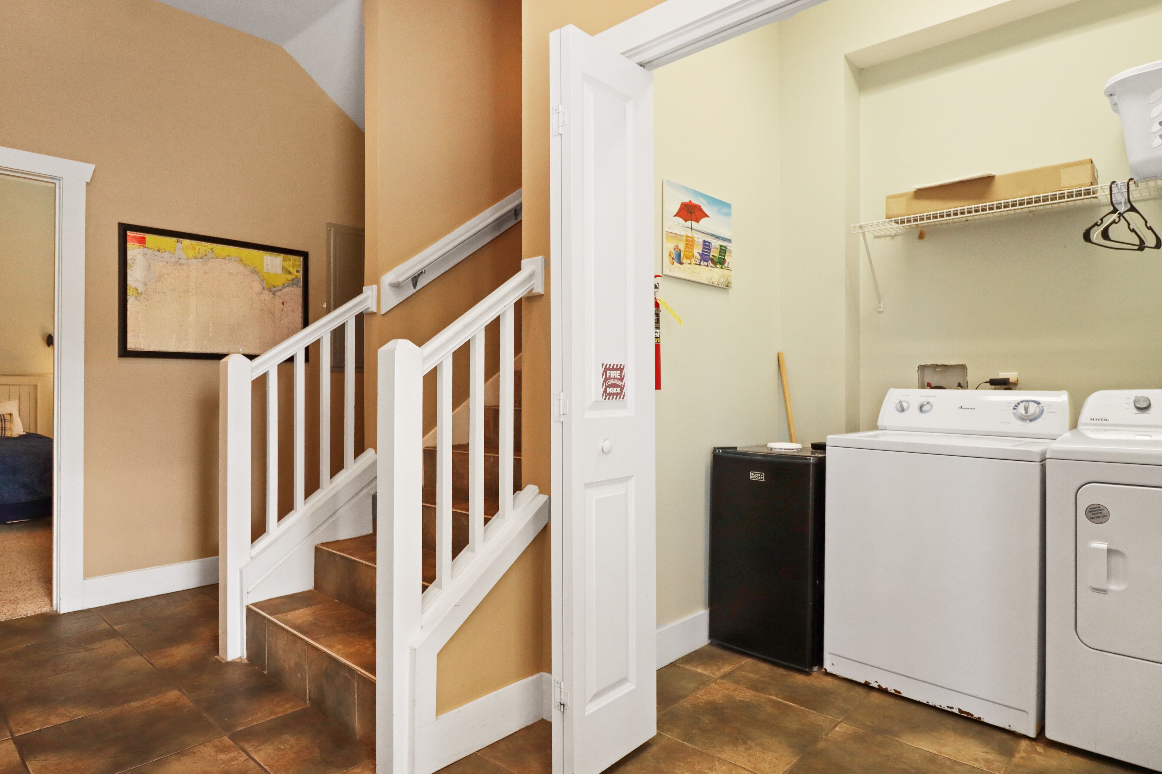 A laundry room with a white door, a washing machine, and a dryer.