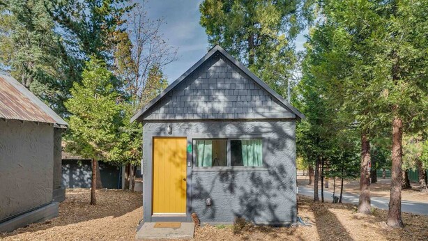 A small cabin with a yellow door, surrounded by trees. - Cabin #4 - The Perch at Twin Peaks (Twin Peaks)