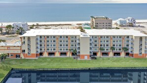 Ein großes Hotel mit mehreren Etagen, einem Schwimmbad und Blick auf den Strand.