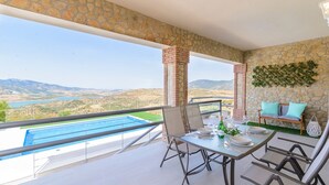 A balcony with a pool, dining table, chairs, and a view of the landscape. - Jacaranda del Gastor by Ruralidays (Cádiz)