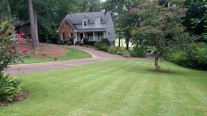 A house with a stone facade, a grey roof, and a front porch. - Auburn Gameday Retreat (Opelika)