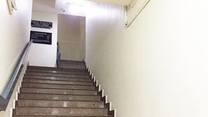 A staircase with a handrail, leading to a landing with a sign.