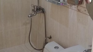 A bathroom with a shower, toilet, and sink.