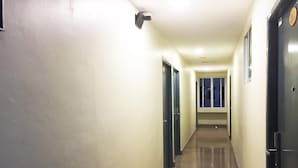A long, narrow hallway with doors on both sides, leading to rooms.
