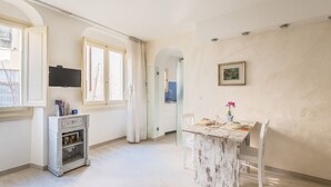 Una cocina amplia con comedor, televisor y un cuadro en la pared.