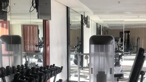 Une salle de sport équipée de matériel de musculation, notamment des haltères et un banc de développé couché.