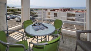 A balcony with a table and chairs, overlooking a parking area and buildings. - 1 bedroom gorgeous apartment in Ajaccio (Ajaccio)