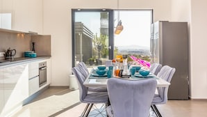 A modern kitchen with a dining area, large windows, and a view of the landscape. - Luxurious home in Glavina Donja (Glavina Donja)