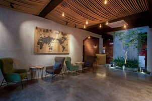 Ein modernes Interieur mit einer Weltkarte als Wandgemälde, einer Holzzahl und einer Sitzecke mit Tischen.