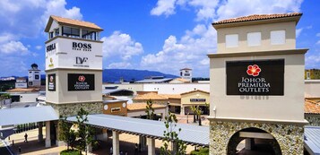 A commercial area with signage for 'Furland Boss' and 'Johor Premium Outlets'.