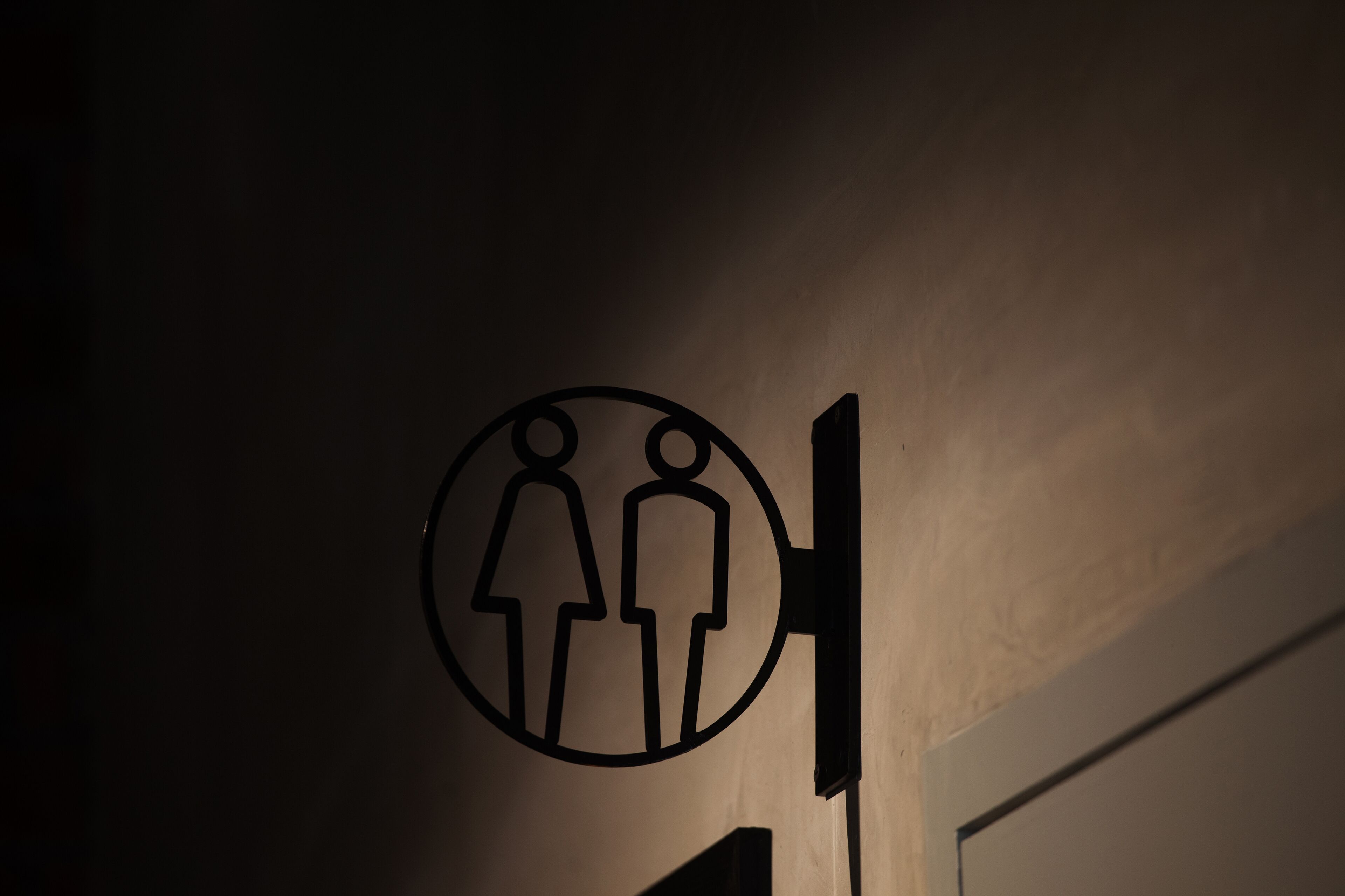 A restroom sign with a male and female symbol.