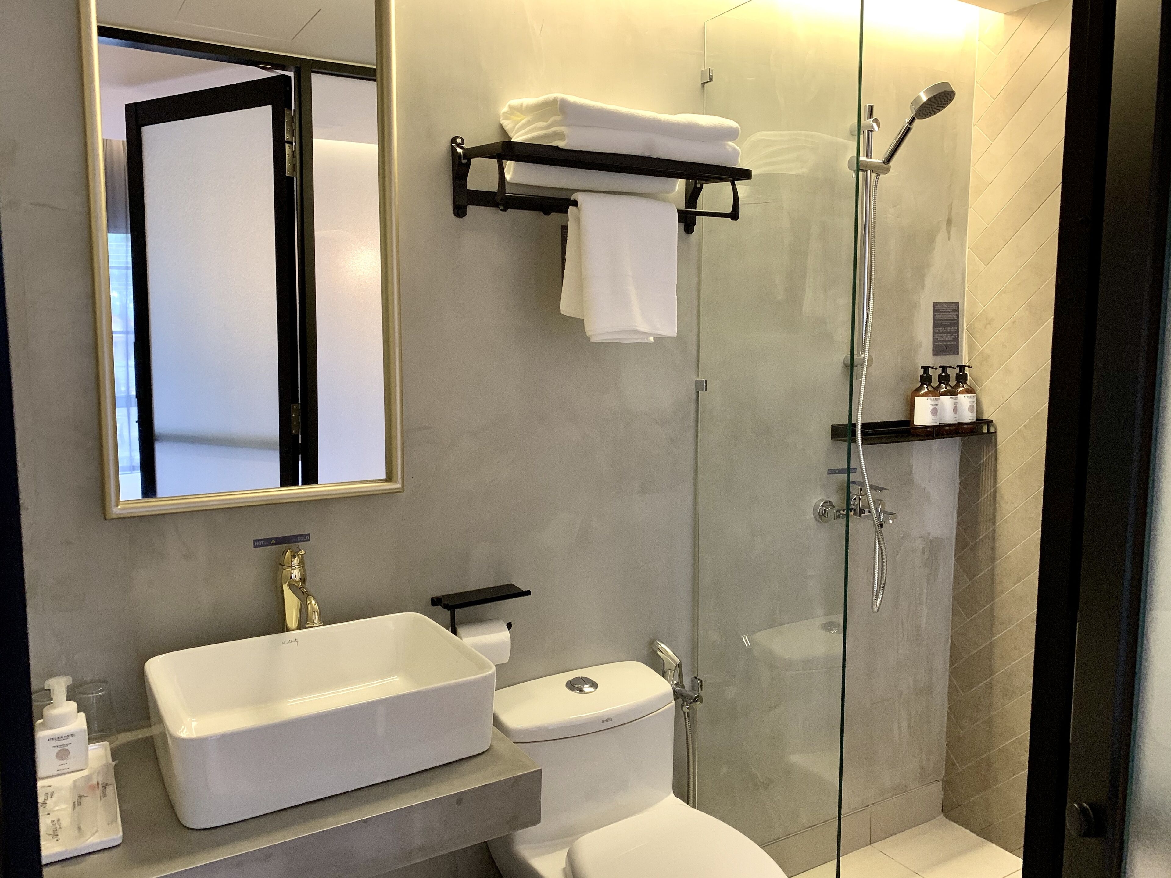 Ein modernes Badezimmer mit einer einteiligen Duschkabine, einem weißen Waschbecken und einer Toilette.