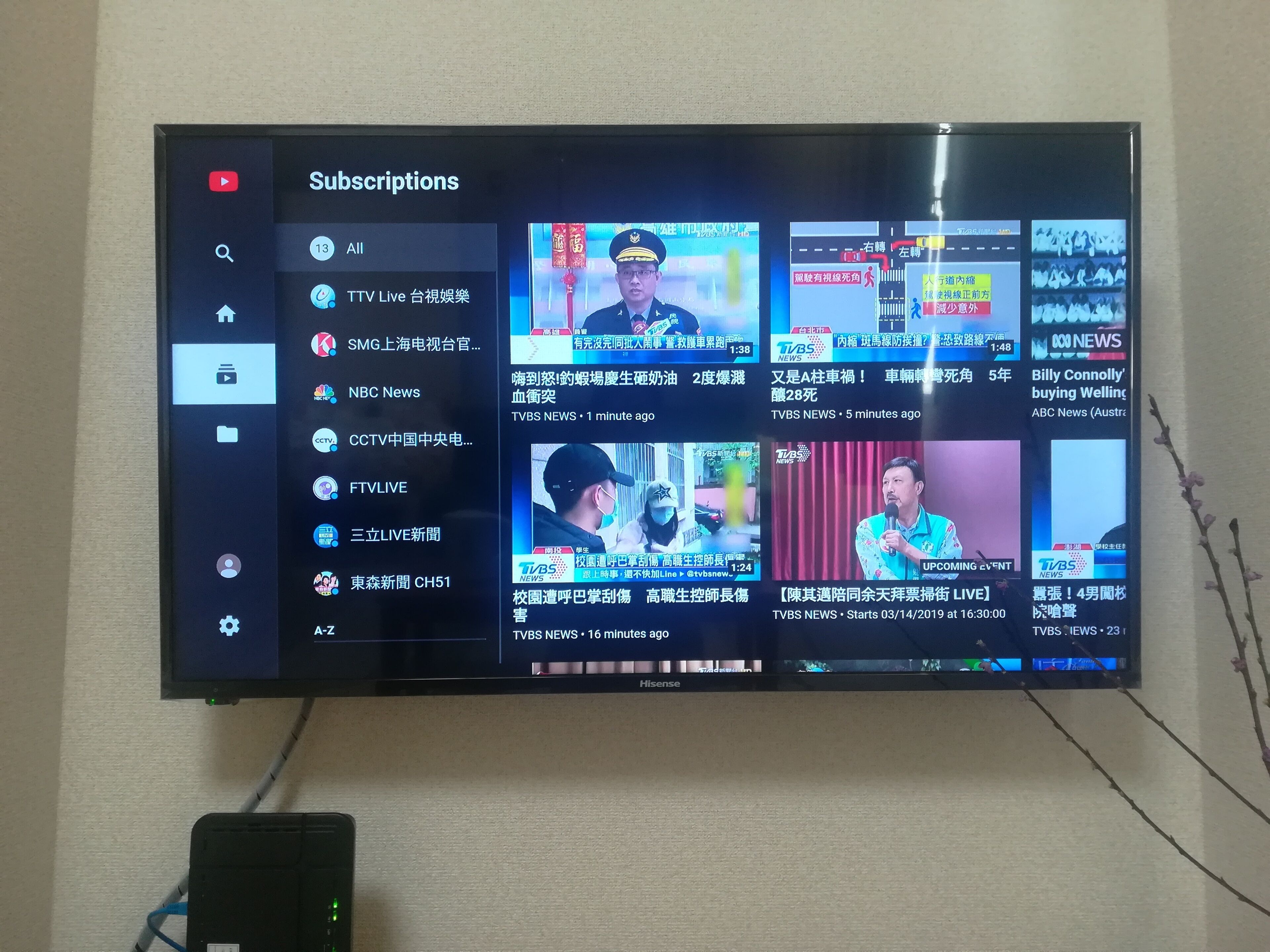 A television displaying a YouTube channel with various news and entertainment content.