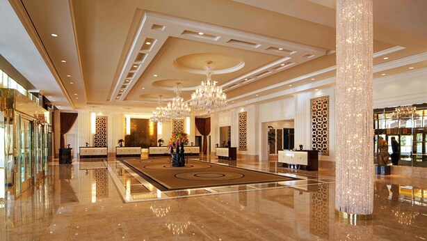 A spacious lobby with a polished marble floor, elegant chandeliers, and a grand reception desk. - 2. 2 miles to convention center (Las Vegas)