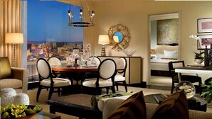 A hotel room with a city view, a dining area with a table and chairs, and a bedroom with a bed and a painting. - 2. 2 miles to convention center (Las Vegas)