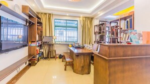 A modern living room with a large TV, wooden furniture, and a bookshelf. - Tea farmer Inn in West Lake Hangzhou (Hangzhou)