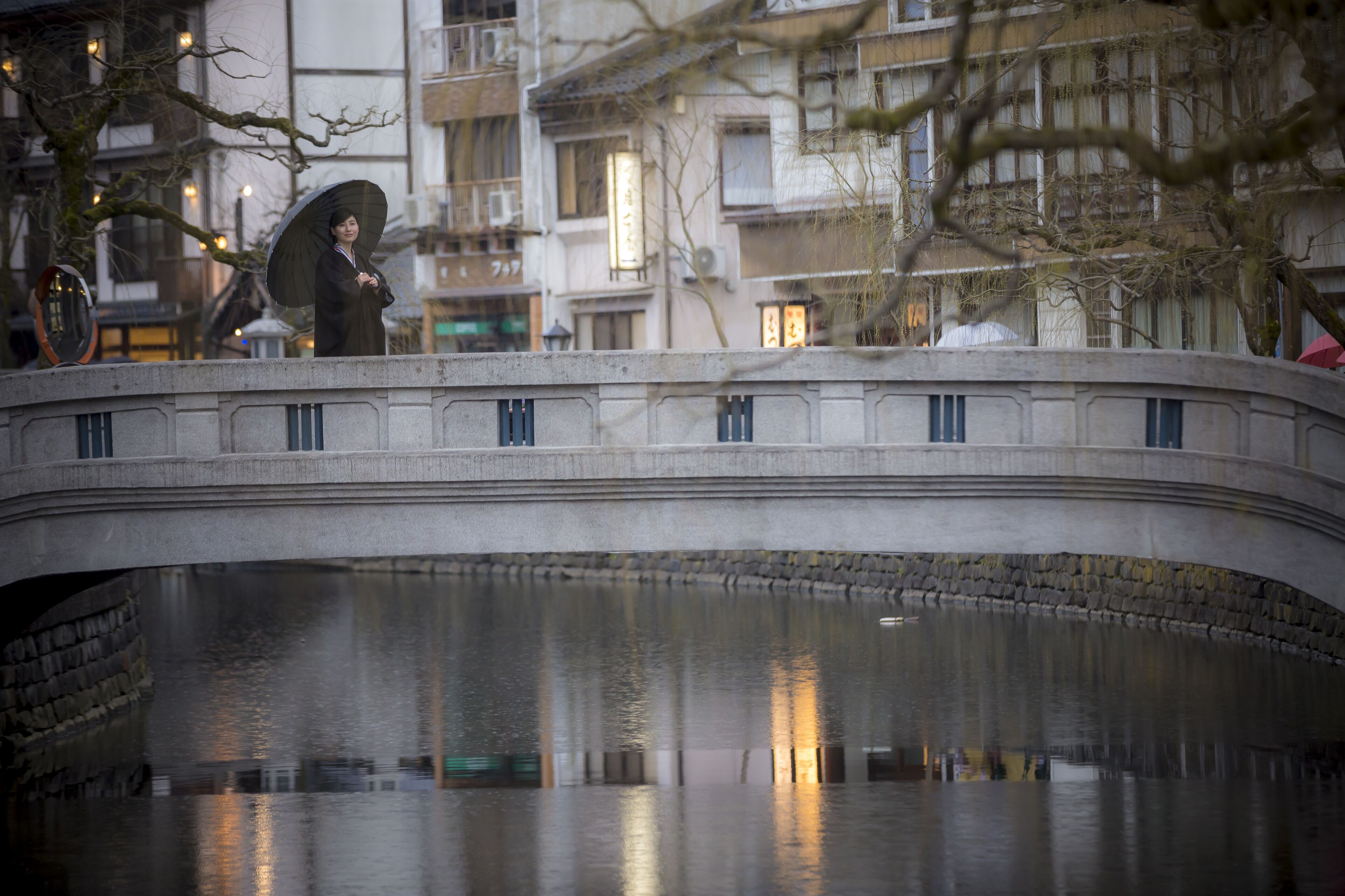 Un puente de piedra sobre aguas tranquilas, con edificios al fondo.