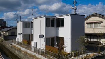 Un edificio residencial moderno con techo plano, ventanas grandes y una antena parabólica visible.