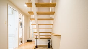 A modern interior with a wooden staircase, tiled floor, and white walls. - Rakuten STAY HOUSE x WILLSTYLE Haginishitamachi (Hagi)