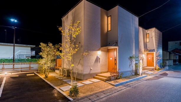 A modern two-story building with a flat roof, large windows, and a well-lit entrance. - Rakuten STAY HOUSE x WILLSTYLE Haginishitamachi (Hagi)