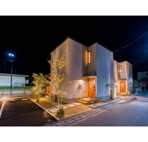 Un bâtiment moderne à deux étages, doté d’un toit plat, de grandes fenêtres et d’une entrée bien éclairée.