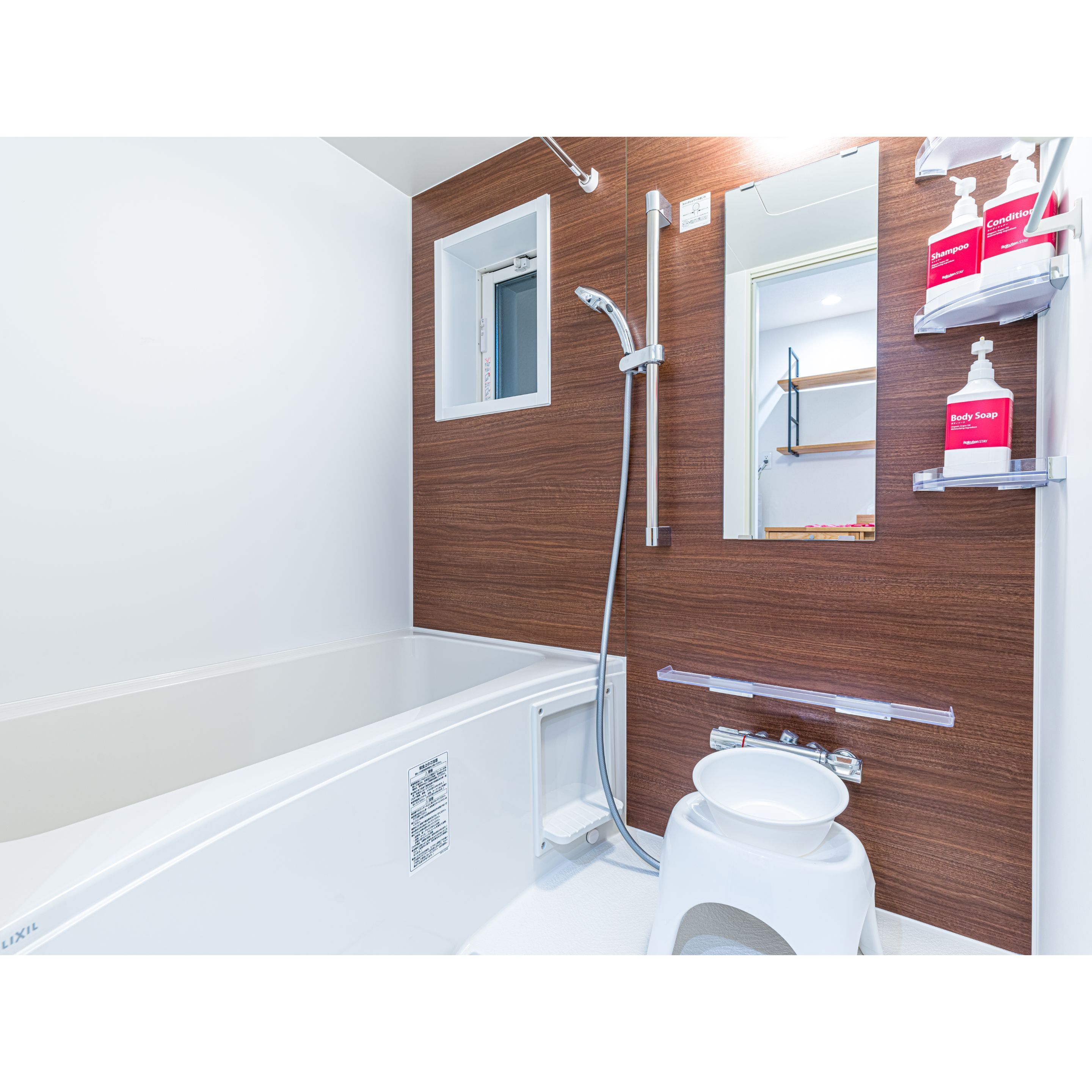 Ein modernes Badezimmer mit einer Wand im Holzdesign, einer weißen Badewanne, einer Dusche und einem Waschbecken mit Spiegel.