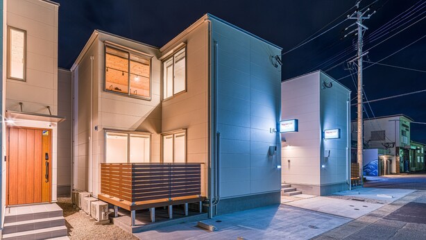 Un immeuble de deux étages avec une entrée bien visible et une enseigne indiquant « Séjour à l’hôtel Regis ».